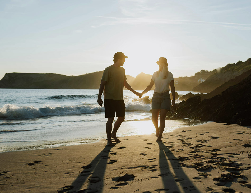 Photo of a couple holding hands walking on a beach