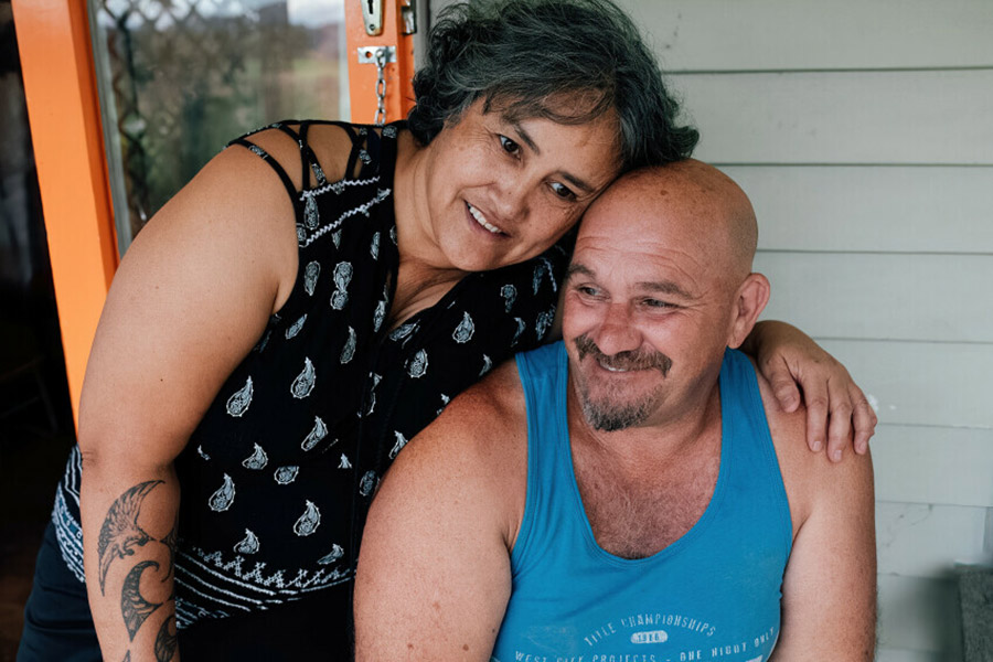 Photo of a husband and wife holding each other, smiling and relaxed