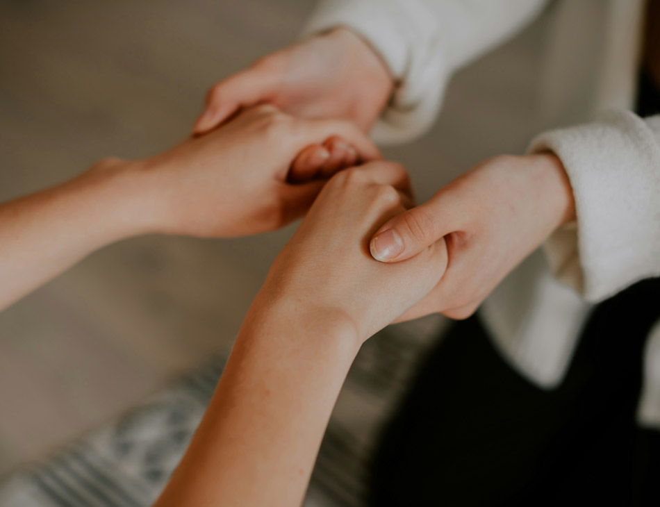 Photo of a person holding another person's hands in a show of support